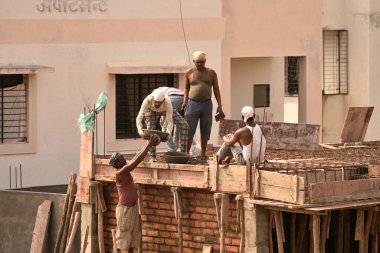 MUMBAI, MAHARASHTRA, INDIA 19 DECEMBER 2019 : Construction workers working on a building development site. In India building workers are not wear any safety measures at work.