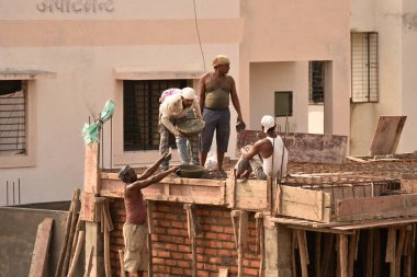 MUMBAI, MAHARASHTRA, INDIA 19 DECEMBER 2019 : Construction workers working on a building development site. In India building workers are not wear any safety measures at work.
