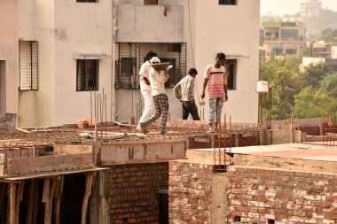 MUMBAI, MAHARASHTRA, INDIA 19 DECEMBER 2019 : Construction workers working on a building development site. In India building workers are not wear any safety measures at work.