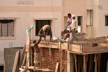 MUMBAI, MAHARASHTRA, INDIA 19 DECEMBER 2019 : Construction workers working on a building development site. In India building workers are not wear any safety measures at work.