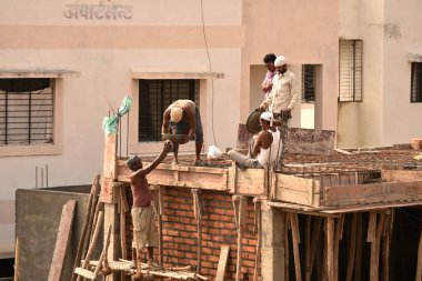 MUMBAI, MAHARASHTRA, INDIA 19 DECEMBER 2019 : Construction workers working on a building development site. In India building workers are not wear any safety measures at work.