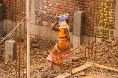 MUMBAI, MAHARASHTRA, INDIA 19 DECEMBER 2019 : Construction workers working on a building development site. In India building workers are not wear any safety measures at work.