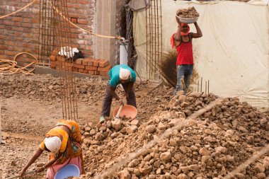MUMBAI, MAHARASHTRA, INDIA 19 DECEMBER 2019 : Construction workers working on a building development site. In India building workers are not wear any safety measures at work.