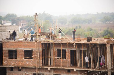 MUMBAI, MAHARASHTRA, INDIA 19 DECEMBER 2019 : Construction workers working on a building development site. In India building workers are not wear any safety measures at work.