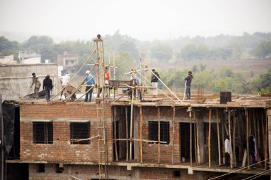 MUMBAI, MAHARASHTRA, INDIA 19 DECEMBER 2019 : Construction workers working on a building development site. In India building workers are not wear any safety measures at work.