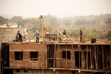 MUMBAI, MAHARASHTRA, INDIA 19 DECEMBER 2019 : Construction workers working on a building development site. In India building workers are not wear any safety measures at work.