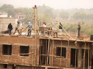 MUMBAI, MAHARASHTRA, INDIA 19 DECEMBER 2019 : Construction workers working on a building development site. In India building workers are not wear any safety measures at work.