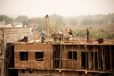 MUMBAI, MAHARASHTRA, INDIA 19 DECEMBER 2019 : Construction workers working on a building development site. In India building workers are not wear any safety measures at work.