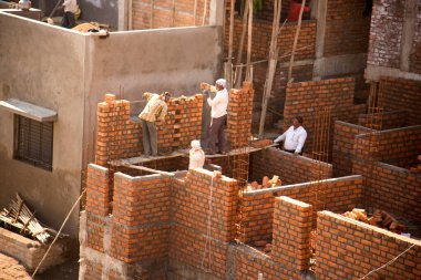 MUMBAI, MAHARASHTRA, INDIA 19 DECEMBER 2019 : Construction workers working on a building development site. In India building workers are not wear any safety measures at work.