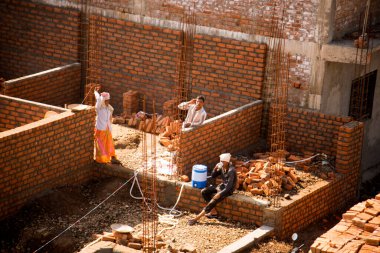 MUMBAI, MAHARASHTRA, INDIA 19 DECEMBER 2019 : Construction workers working on a building development site. In India building workers are not wear any safety measures at work.