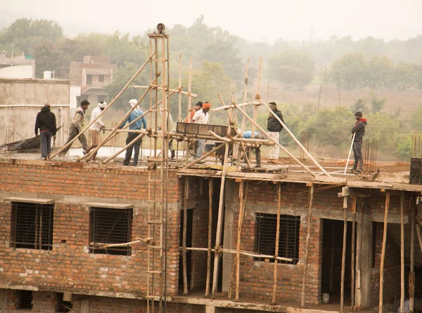 MUMBAI, MAHARASHTRA, INDIA 19 DECEMBER 2019 : Construction workers working on a building development site. In India building workers are not wear any safety measures at work.