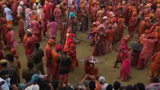 女性はインドのナンガオンで行われたラスマール ホリの祭典で 長い棒を持つ男性を打ち負かしました ホリはインドで最も有名な宗教祭です — ストック動画