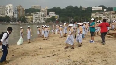 MUMBAI, INDIA, 24 SEPTEMBER 2018: Ganesha 'nın Hint festivali sonrası Güney Mumbai' deki Chaupati Sahili 'ni temizlemek için birbirlerine yardım eden bir grup genç öğrenci. 