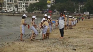 MUMBAI, INDIA, 24 SEPTEMBER 2018: Ganesha 'nın Hint festivali sonrası Güney Mumbai' deki Chaupati Sahili 'ni temizlemek için birbirlerine yardım eden bir grup genç öğrenci. 