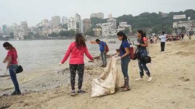 MUMBAI, INDIA, 24 SEPTEMBER 2018: Ganesha 'nın Hint festivali sonrası Güney Mumbai' deki Chaupati Sahili 'ni temizlemek için birbirlerine yardım eden bir grup genç öğrenci. 