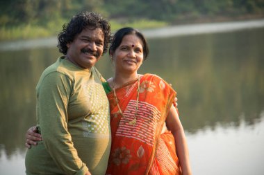 Hintli çift eğleniyor, birbirlerini göl kenarında tutuyorlar, Hint yaşam tarzı portresi..