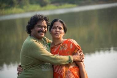 Hintli çift eğleniyor, birbirlerini göl kenarında tutuyorlar, Hint yaşam tarzı portresi..