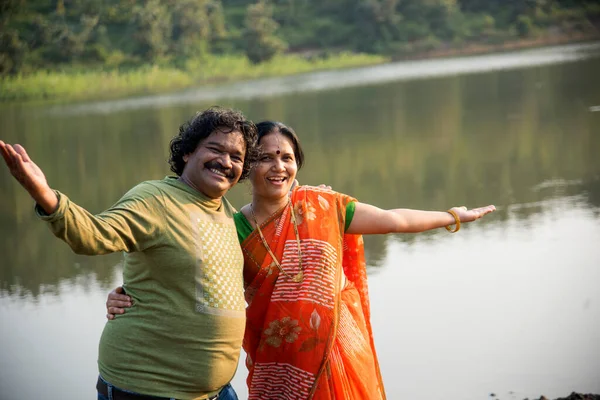 Hintli çift eğleniyor, birbirlerini göl kenarında tutuyorlar, Hint yaşam tarzı portresi..