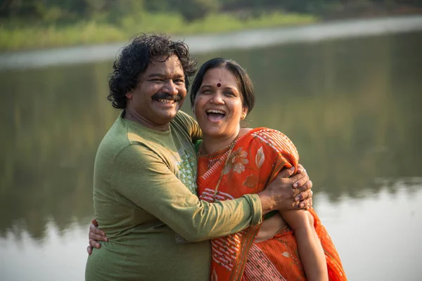 Hintli çift eğleniyor, birbirlerini göl kenarında tutuyorlar, Hint yaşam tarzı portresi..