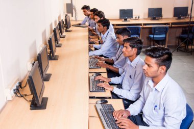 NAGPUR, INDIA - 11 Nisan 2016: Teknoloji öğrencileri araştırma için bilgisayarları kullanarak masada oturuyorlar. Çalışmaları için bilgisayardan bilgi alan gençler. 