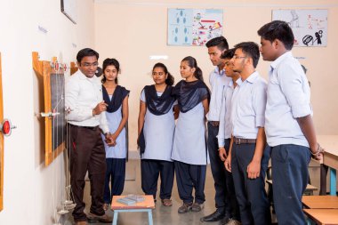 NAGPUR, MAHARASHTRA, INDIA - 9 Nisan 2016: Sınıfta genç öğrencileri gösterip eğiten üniversite profesörü