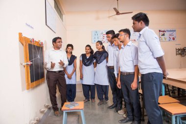 NAGPUR, MAHARASHTRA, INDIA - 9 Nisan 2016: Sınıfta genç öğrencileri gösterip eğiten üniversite profesörü