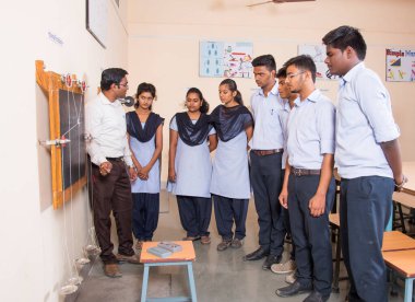 NAGPUR, MAHARASHTRA, INDIA - 9 Nisan 2016: Sınıfta genç öğrencileri gösterip eğiten üniversite profesörü