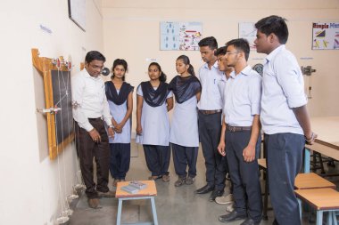 NAGPUR, MAHARASHTRA, INDIA - 9 Nisan 2016: Sınıfta genç öğrencileri gösterip eğiten üniversite profesörü