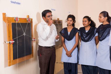 NAGPUR, MAHARASHTRA, INDIA - 9 Nisan 2016: Sınıfta genç öğrencileri gösterip eğiten üniversite profesörü