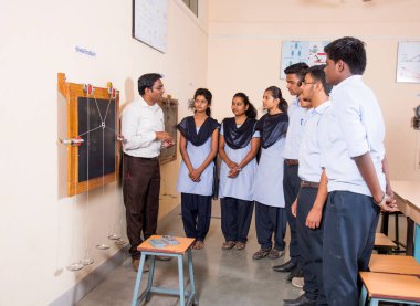 NAGPUR, MAHARASHTRA, INDIA - 9 Nisan 2016: Sınıfta genç öğrencileri gösterip eğiten üniversite profesörü