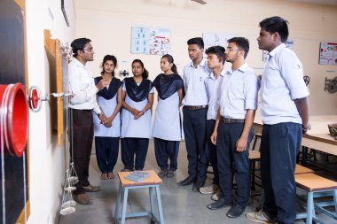 NAGPUR, MAHARASHTRA, INDIA - 9 Nisan 2016: Sınıfta genç öğrencileri gösterip eğiten üniversite profesörü