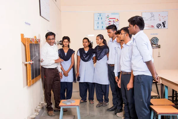 NAGPUR, MAHARASHTRA, INDIA - 9 Nisan 2016: Sınıfta genç öğrencileri gösterip eğiten üniversite profesörü