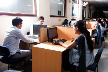 NAGPUR, MAHARASHTRA, INDIA - 11 Nisan 2016: Bilgi Teknolojisi 'nin tanımlanamayan genç öğrencileri çalışmaları için bilgisayar kullanıyorlar.