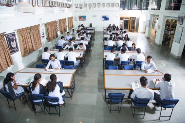 AMRAVATI, MAHARASHTRA, INDIA - 11 Nisan 2016: Üniversite kütüphanesinde tanımlanamayan bir grup genç öğrenci birlikte okuyorlar.