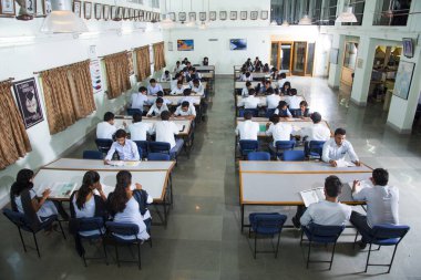 AMRAVATI, MAHARASHTRA, INDIA - 11 Nisan 2016: Üniversite kütüphanesinde tanımlanamayan bir grup genç öğrenci birlikte okuyorlar.