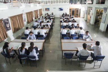 AMRAVATI, MAHARASHTRA, INDIA - 11 Nisan 2016: Üniversite kütüphanesinde tanımlanamayan bir grup genç öğrenci birlikte okuyorlar.