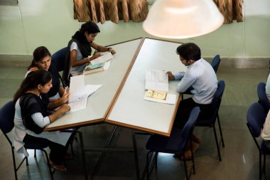 AMRAVATI, MAHARASHTRA, INDIA - 11 Nisan 2016: Üniversite kütüphanesinde tanımlanamayan bir grup genç öğrenci birlikte okuyorlar.