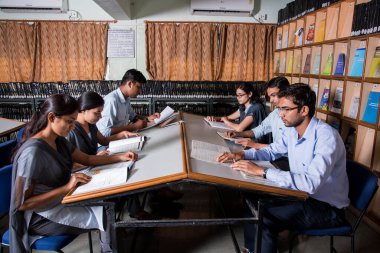 AMRAVATI, MAHARASHTRA, INDIA - 11 Nisan 2016: Üniversite kütüphanesinde tanımlanamayan bir grup genç öğrenci birlikte okuyorlar.