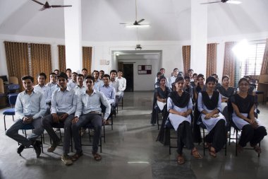 AMRAVATI, MAHARASHTRA, INDIA - 11 Nisan 2016: Üniversitelerinin ses video salonunda belgesel izlemek için birlikte oturan kimliği belirsiz bir grup genç öğrenci.