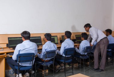 NAGPUR, MAHARASHTRA, INDIA, 11 Nisan 2016: Genç mühendislik öğrencilerini atölyede sergileyen ve eğiten üniversite profesörü, Mühendislik Öğrencileri.