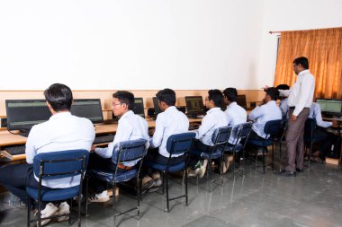 NAGPUR, MAHARASHTRA, INDIA, 11 Nisan 2016: Genç mühendislik öğrencilerini atölyede sergileyen ve eğiten üniversite profesörü, Mühendislik Öğrencileri.