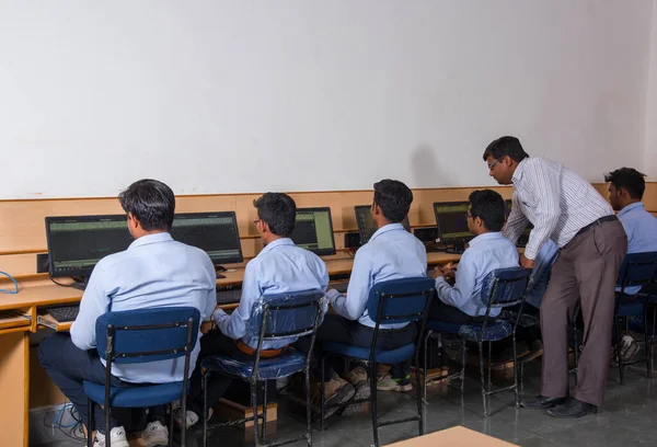 NAGPUR, MAHARASHTRA, INDIA, 11 Nisan 2016: Genç mühendislik öğrencilerini atölyede sergileyen ve eğiten üniversite profesörü, Mühendislik Öğrencileri.