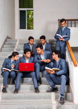 NAGPUR, MAHARASHTRA, INDIA, 13 NİSAN 2016: Üniversite kampüsünün merdivenlerinde yürüttükleri çalışma projesi hakkında konuşan kimliği belirsiz genç MBA öğrencileri.