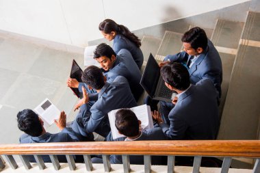 NAGPUR, MAHARASHTRA, INDIA, 13 NİSAN 2016: Üniversite kampüsünün merdivenlerinde yürüttükleri çalışma projesi hakkında konuşan kimliği belirsiz genç MBA öğrencileri.