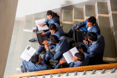 NAGPUR, MAHARASHTRA, INDIA, 13 NİSAN 2016: Üniversite kampüsünün merdivenlerinde yürüttükleri çalışma projesi hakkında konuşan kimliği belirsiz genç MBA öğrencileri.