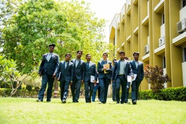 NAGPUR, MAHARASHTRA, INDIA, 13 NİSAN 2016: Kimliği belirsiz genç MBA öğrencilerinin birlikte yürüdüğü ve üniversite kampüsünde eğlendiği bir grup.