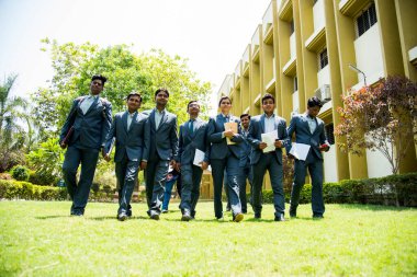 NAGPUR, MAHARASHTRA, INDIA, 13 NİSAN 2016: Kimliği belirsiz genç MBA öğrencilerinin birlikte yürüdüğü ve üniversite kampüsünde eğlendiği bir grup.
