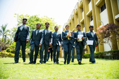 NAGPUR, MAHARASHTRA, INDIA, 13 NİSAN 2016: Kimliği belirsiz genç MBA öğrencilerinin birlikte yürüdüğü ve üniversite kampüsünde eğlendiği bir grup.