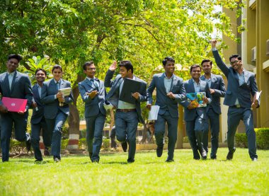 NAGPUR, MAHARASHTRA, INDIA, 13 NİSAN 2016: Kimliği belirsiz genç MBA öğrencilerinin birlikte yürüdüğü ve üniversite kampüsünde eğlendiği bir grup.
