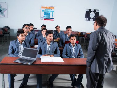 NAGPUR, MAHARASHTRA, INDIA, 13 Nisan 2016: Sınıfta MBA 'nın genç öğrencilerine tanımlanamayan üniversite profesörü.